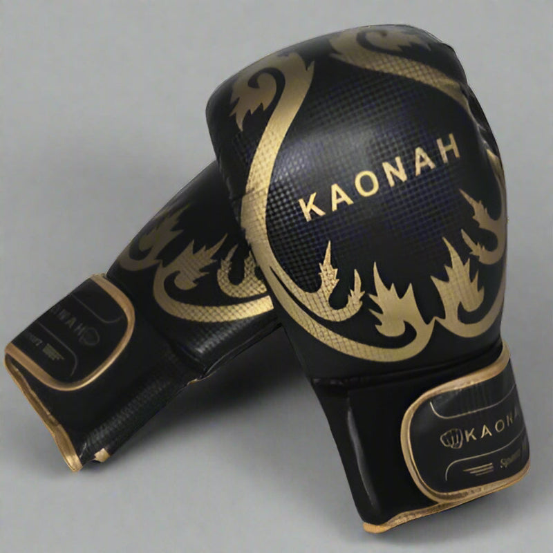 Muay Thai Boxhandschuhe für Anfänger in schwarz und gold mit Kaonah-Logo.